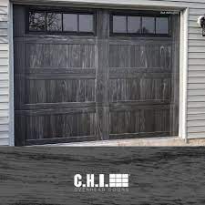 stamped carriage house garage door in new carbon oak realistic faux wood garage doors by c h i in 2021 garage doors faux wood garage door overhead door