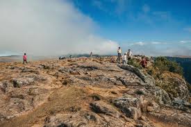 cambara do sul, brasilien - 18. juli 2019. menschen auf dem gipfel der  klippe am fortaleza canyon mit felsiger landschaft und wolken in der nähe  von cambara do sul. eine kleine ländliche