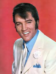 Elvis Presley in a bright white suit and carnation