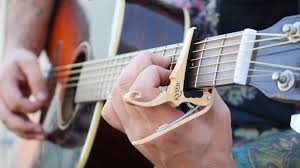 Close up of a musician attaching a capo