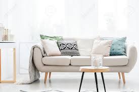 What i love so much about going with a beige sofa is that they don't restrict your decor options. Kerze In Einem Glasgefass Auf Tabelle Vor Beige Sofa Mit Kissen Im Wohnzimmer Der Skandinavischen Art Lizenzfreie Fotos Bilder Und Stock Fotografie Image 90657470