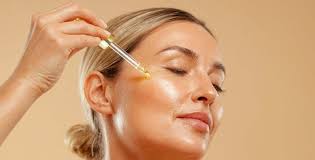 woman applying facial oil before lymphatic drainage massage