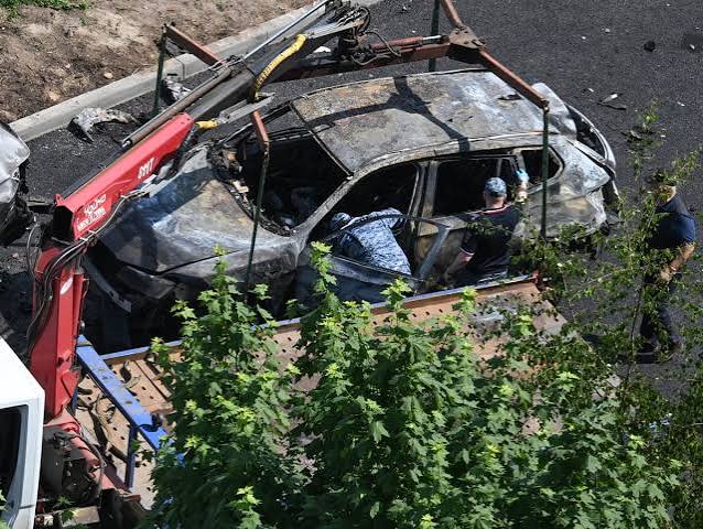 A charred vehicle wreckage in Russia following a targeted car bombing involving a high-profile military contractor.