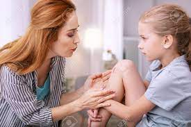 She can only say what she thinks and hope for the best. It Will Not Hurt Nice Young Mother Blowing At The Scratch While Stock Photo Picture And Royalty Free Image Image 103100407