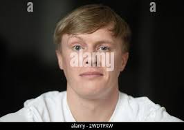 18 January 2024, Baden-Württemberg, Crailsheim: Influencer Liam Carpenter  sits in his apartment. Liam Carpenter is