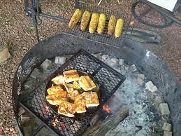 Using Cast Iron Over The Open Fire With A Campfire Swing Arm And Warming Rack Cooking Over Fire Fire Cooking Campfire Cooking Equipment
