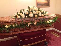 Decorated with artificial flowers, isolated on white background. Coffin Spray And Garland Around Wicker Coffin Dartford Florist Ltd Formally St Albans Flowers Dartford Kent