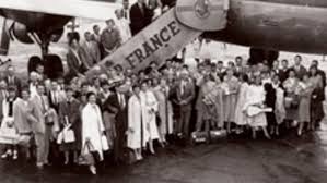 6 seater wooden dining table with 4 white chairs & bench for 2, & sideboard on one side wall with storage & 3d wall panels highlighted with spot lights. A Whole New World Stanford Magazine