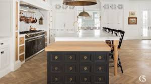 Black kitchen cabinets are tempered here with the light wood island and countertops. Our Favorite Black Kitchen Cabinet Paint Colors Christopher Scott Cabinetry