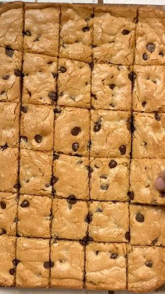 Blondies stacked on a plate with a glass of milk
