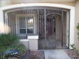 This scene translates well with any home boasting an ample driveway or front yard and is perfect for the budding boheme inside of you. Wrought Iron Entry Enclosure Not The Best Looking Ideaa But As A Retrofit Not Bad Wrought Iron Front Door Front Door Entryway Door Gate Design