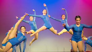 Sophomores Hattie Harden, Eva Hill, and freshman Katie Reda leap during the  JV jazz routine. Photo by Lucy Morantz