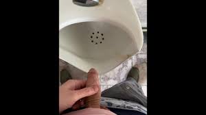 Un hombre orinando en un baño público, POV