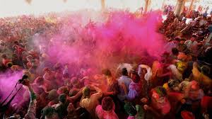 Group of travelers celebrating Holi together in Gopeshwar with mountains in the background