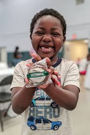 Masters Tournament moon pies bring smiles to kids as they eat Sunday dinner  at the Augusta Dream Center. Thousands of bags of barbecue chips round out  bag lunches for guests at The