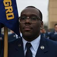 Navy Junior ROTC color guard members march in formation across the parking  lot during field day exercises