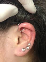 helix pierced with a heart shaped ring ear piercings heart shaped rings heart shapes
