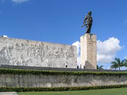 On magenta background, head shot of che guevara with yellow stars and silhouette of south america in upper right. Che Guevara Mausoleum Wikipedia