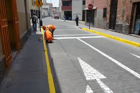 Una guarnición (sardinel) en una calle de Arequipa recién pintada de amarillo, con un contraste limpio entre el pavimento y el bordillo.