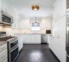 Wood open shelving gives your eye some breathing room and provides additional visual interest. White Kitchen Cabinets With Black And Gray Granite Countertops Transitional Kitchen