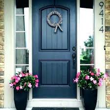 It features a white stoop roof right above it, which is supported by a pair of two square columns. Navy Front Door Navy Blue Front Door Red Brick Navy Blue Front Door Dark Images Gray Color Exterior Door Paint Colors Best Front Doors Front Door Paint Colors