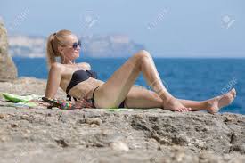 Both men and women love heels (although, sometimes we don't love to wear them!). Female Person Sunbathing On Wild Rocky Beach Attractive Young Stock Photo Picture And Royalty Free Image Image 152377416