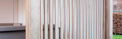 Die montierte wandverkleidung erscheint in einem erstaunlichen aussehen und lässt die linearen lamellen frei schwebend erscheinen. Holzlamellen Carpentier Hardwood Solutions