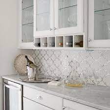 You can create an expanse of single color mirror tiles, which reflect light and help open up the room. Arabesque Carrera Marble Backsplash Design Ideas