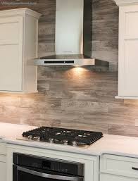 Porcelain Floor Tile With A Gray Woodgrain Pattern Is Installed As A Backsplash In This Painted Ki Kitchen Backsplash Designs Tuscan Kitchen Wood Backsplash