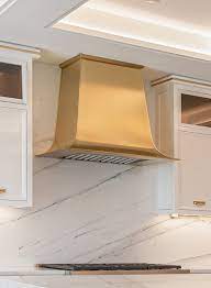 Modern style range hood decorated with gold straps. Madison Range Hood Madison Range Hoods Art Of Range Hoods