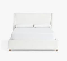 Adding upholstery for these bed frames low profile helps add visual weight, giving the frame a touch of color. York Upholstered Platform Bed Pottery Barn