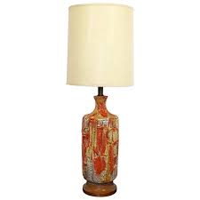 The light sources are concealed from sight in the Mid Century Modern Orange Fat Lava Drip Glazed Ceramic Table Lamp Brass Wood At 1stdibs