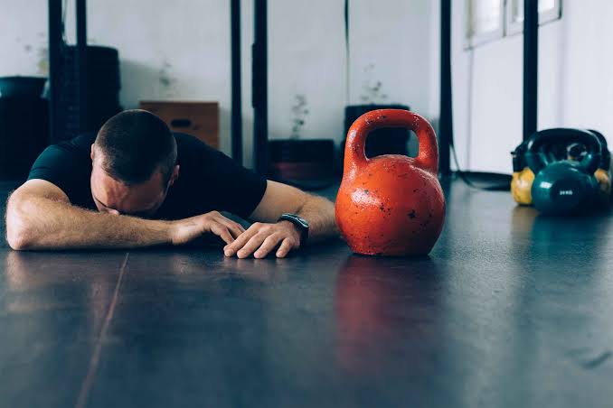 guy laying next to kettlebells