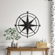 It's made from metal and showcases a circular silhouette with the cardinal directions in bold, clear letters. August Grove Outdoor Metal Wall Compass Reviews Wayfair