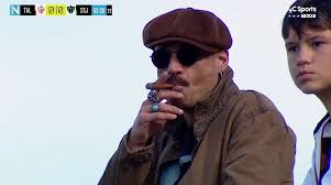 Dani Stone?, vestido de gala y fumando un habano en el partido de San Martín