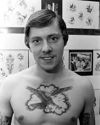 Soccer fanatic Ray Morris with his Liverpool FC back piece showcasing the  team's ground and portraits of Bob Paisley and Kenny Dalglish, pictured  with tattooist Brenda Clarke. August 1980. Photographer: Ron B. . . . #