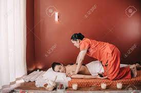 Side View Of Asian Masseur Doing Hot Stone Massage To Woman In Spa Salon  Stock Photo, Picture and Royalty Free Image. Image 131182977.