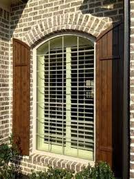 Exterior shutters on arched windows. Outside View Of Arched Shutter On A Brick Wall House Shutters Farmhouse Shutters Wood Shutters Exterior