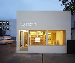 The Soft Light From The White Painted Structure Expels A Warm Glow Into The Street Welcoming Customers In Cafe Interior Design Cafe Shop Design Cafe Exterior