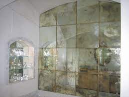 Here, in a bedroom, a pitcher vase with red carnations, a starfish and an alarm clock complete the display. Antiqued Mirror Google Search Antique Mirror Glass Antique Mirror Wall Antique Mirror Tiles