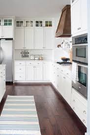 Stunning white cooktop designed with a white wood panel range hood, marble subway tiles and a wolf integrated gas cooktop. Wood Range Hood The Lilypad Cottage