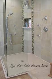 Low Profile Curb In A Solid Surface Shower Pan With Decorative Ceramic Tiles And A Frameless Glass Enclosure H Shower Panels Shower Remodel Bathrooms Remodel