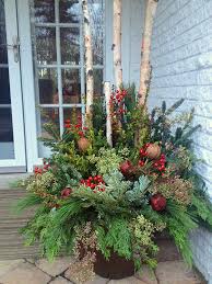 As The Temperatures Drop And The Garden Tucks In For Its Winter Slumber Containers Step Out Of Their Supporti Christmas Planters Christmas Pots Christmas Urns