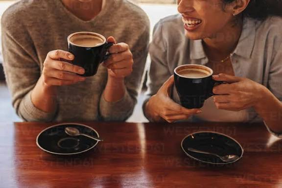 Foto recortada de dos amigas tomando café juntas en una cafetería. Amigas  en una cafetería tomando café. stock photo