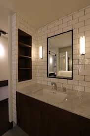 洗面カウンターは大理石の霰を使用 白タイルと黒目地の壁に 黒スチールフレームの鏡 カウンター下にはウォルナットの幕板と収納扉 両サイドに収納を設け 背板に化粧コーナーとして3面鏡を設けている 洗面 リノベーション 洗面台 洗面鏡