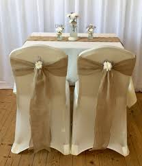 These Beautiful Ivory Chair Covers Being Complimented With Hessian Sashes And Flowers To Give A Rustic Chair Covers Wedding Wedding Chair Sashes Wedding Chairs