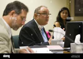 Witness John Stollar Jr. , center, chief of programs and policy for the  Arizona Department of Education, testifies with Administrative Law Judge  Lewis Kowal , left, during a Tucson Unified School District