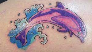 Red rose and dolphin aqua tattoo on side. 15 Fantastic Dolphin Tattoo Design Ideas