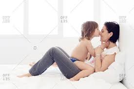 This woman is drop dead gorgeous! Little Girl Kissing Her Mother In A Bed Stock Photo Offset