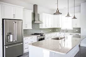 The dark gray cabinetry, light gray walls, and white subway tile backsplash make for a beautiful, neutral canvas for the bold teal blue and yellow décor accented throughout the design. White Kitchen With Light Gray Backsplash Novocom Top